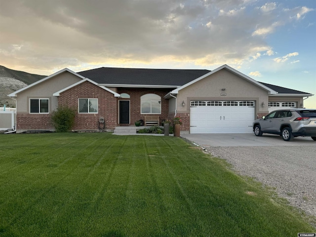 ranch-style house featuring a garage and a lawn