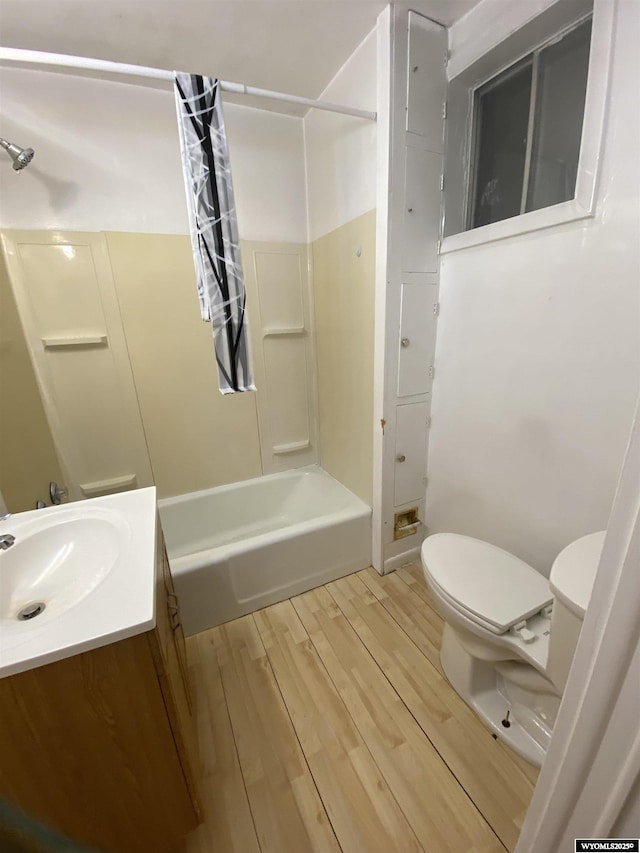 full bathroom with vanity, hardwood / wood-style floors, shower / bathtub combination with curtain, and toilet