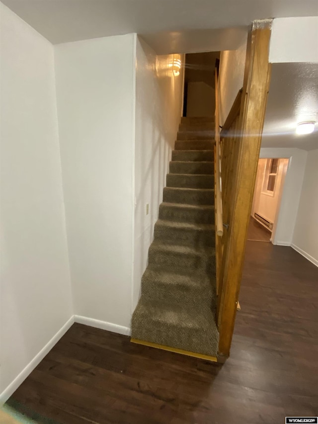 stairway featuring a baseboard radiator and hardwood / wood-style floors