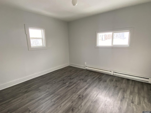 spare room with a baseboard radiator and dark hardwood / wood-style flooring