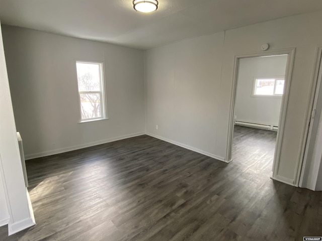 spare room featuring dark hardwood / wood-style flooring and baseboard heating