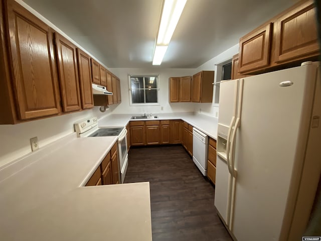 kitchen featuring dark hardwood / wood-style floors, sink, white appliances, and kitchen peninsula