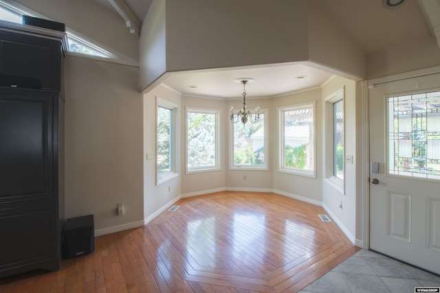 interior space with lofted ceiling, plenty of natural light, a notable chandelier, and light hardwood / wood-style floors