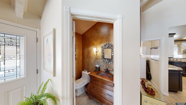 hallway featuring sink, washer / dryer, and light tile patterned floors