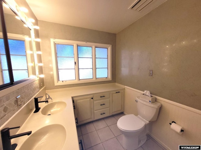 bathroom with tile patterned flooring, vanity, and toilet