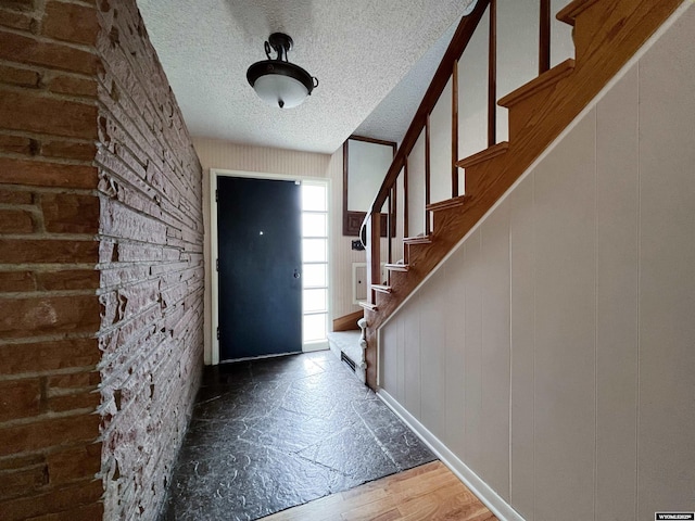 entrance foyer with dark wood-type flooring and a textured ceiling