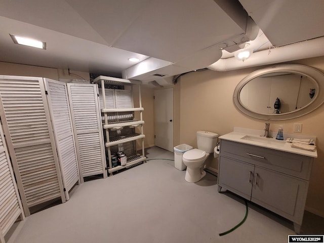 bathroom with vanity, concrete flooring, and toilet