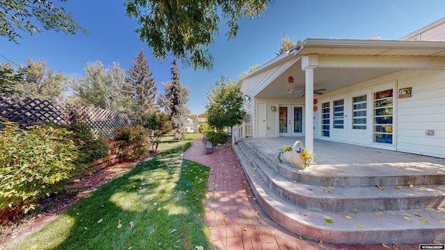 view of yard with french doors, ceiling fan, and a patio