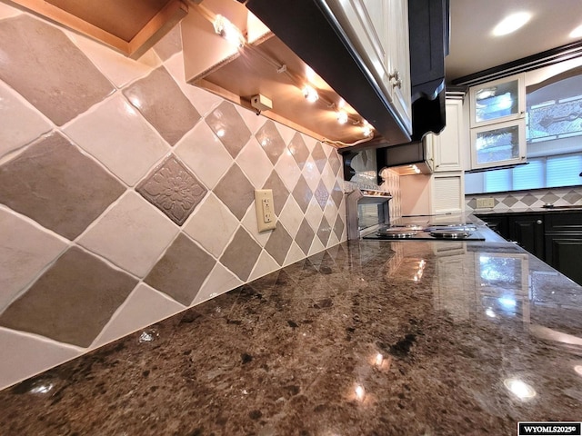 kitchen with white cabinetry, dark stone countertops, black gas stovetop, and decorative backsplash