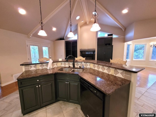 kitchen with pendant lighting, dishwasher, sink, and dark stone countertops