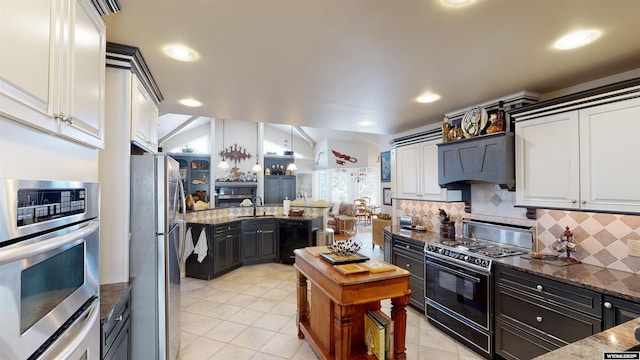 kitchen with premium range hood, black appliances, white cabinets, decorative backsplash, and dark stone counters