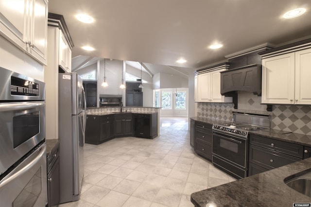 kitchen with vaulted ceiling, appliances with stainless steel finishes, custom range hood, dark stone counters, and decorative backsplash