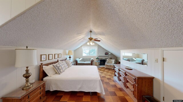 bedroom featuring vaulted ceiling, ceiling fan, and a textured ceiling