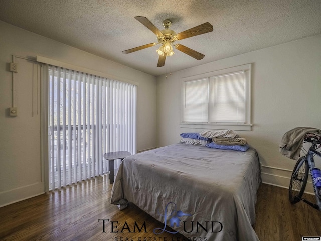 bedroom with ceiling fan, dark hardwood / wood-style flooring, and a textured ceiling