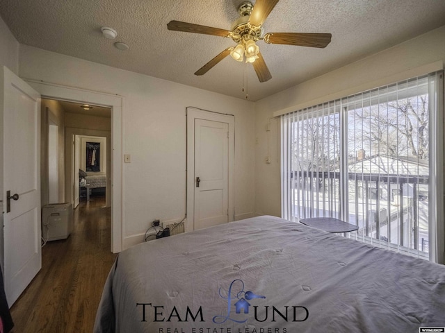 bedroom featuring ceiling fan, dark hardwood / wood-style floors, access to outside, and a textured ceiling