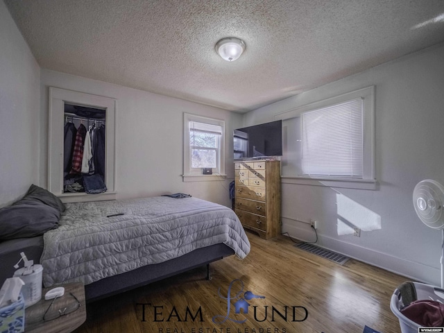 bedroom with hardwood / wood-style flooring and a textured ceiling