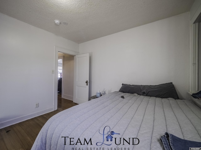 bedroom with dark wood-type flooring and a textured ceiling