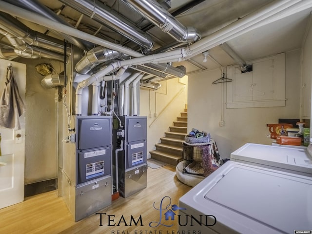 basement featuring washing machine and dryer and light hardwood / wood-style floors