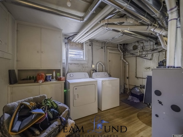 laundry area with light hardwood / wood-style flooring and washer and dryer