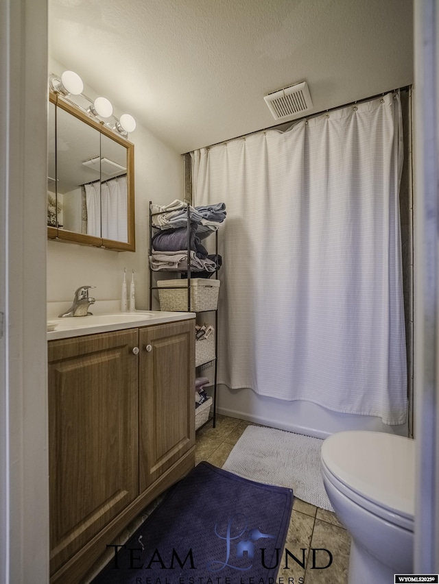 full bathroom featuring tile patterned floors, toilet, a textured ceiling, vanity, and shower / bath combo