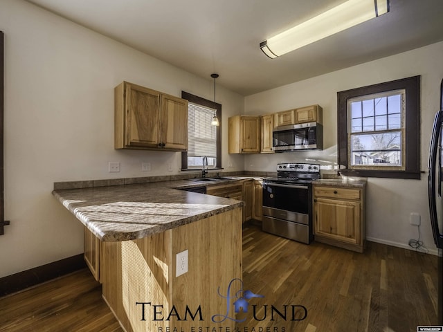 kitchen with pendant lighting, sink, dark hardwood / wood-style flooring, kitchen peninsula, and stainless steel appliances