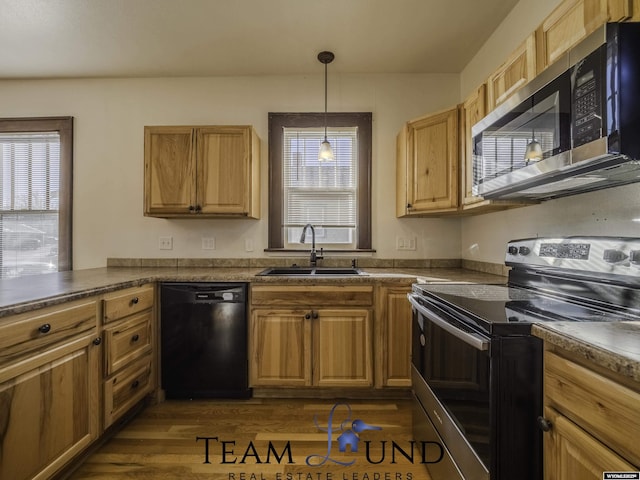 kitchen with appliances with stainless steel finishes, dark hardwood / wood-style flooring, sink, and hanging light fixtures