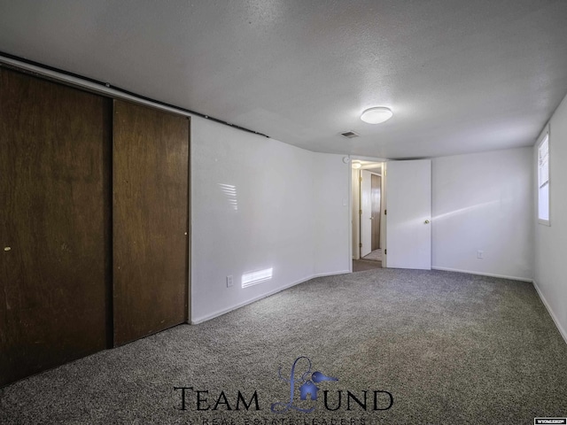 unfurnished bedroom featuring carpet and a textured ceiling