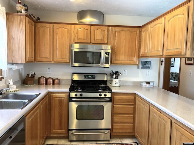 kitchen featuring stainless steel appliances, sink, and a textured ceiling