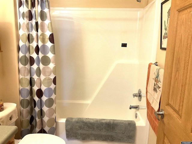 bathroom featuring shower / bathtub combination with curtain and toilet