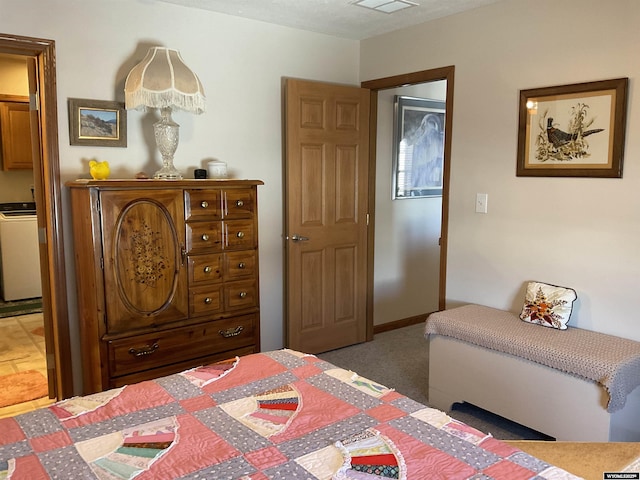 bedroom featuring washer / clothes dryer and carpet