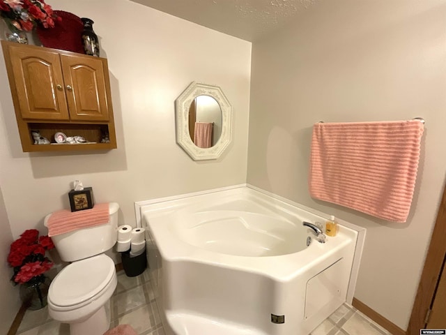 bathroom with tile patterned flooring, a tub, and toilet