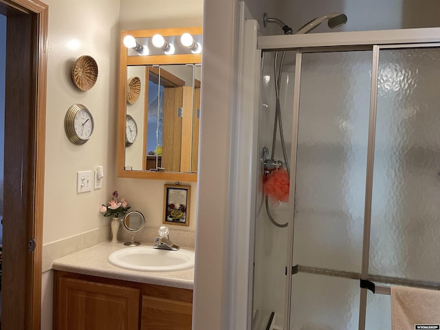 bathroom with vanity and a shower with door