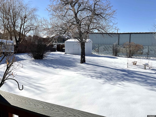 snowy yard with a shed