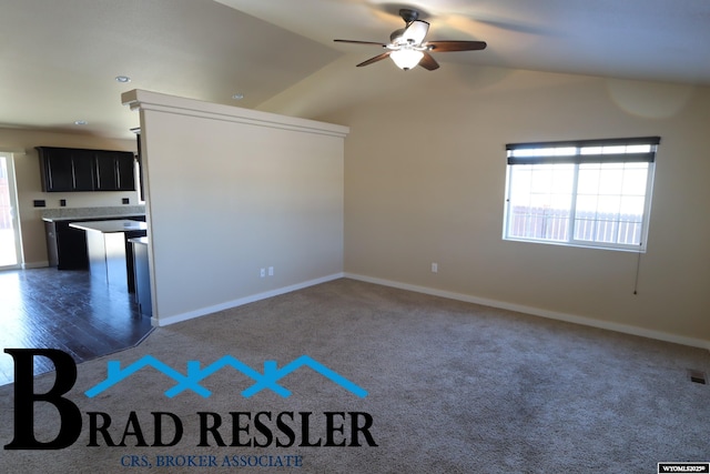 empty room with dark wood-type flooring, vaulted ceiling, and ceiling fan