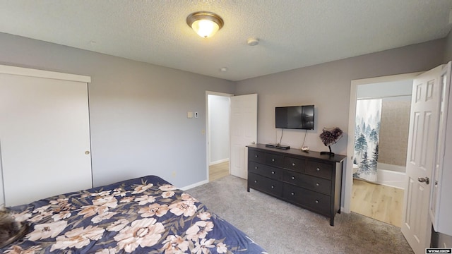 bedroom featuring light colored carpet and a textured ceiling