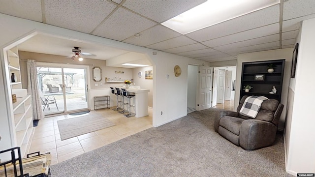 carpeted living room featuring a paneled ceiling and ceiling fan