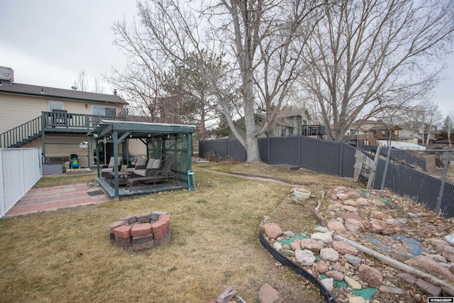 view of yard with a wooden deck, an outdoor living space with a fire pit, and a patio