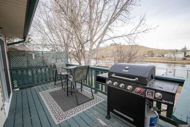 deck with a grill and a water and mountain view