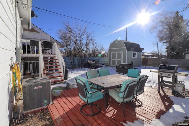 wooden terrace featuring a shed, grilling area, and central AC