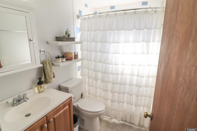 bathroom with vanity, curtained shower, and toilet