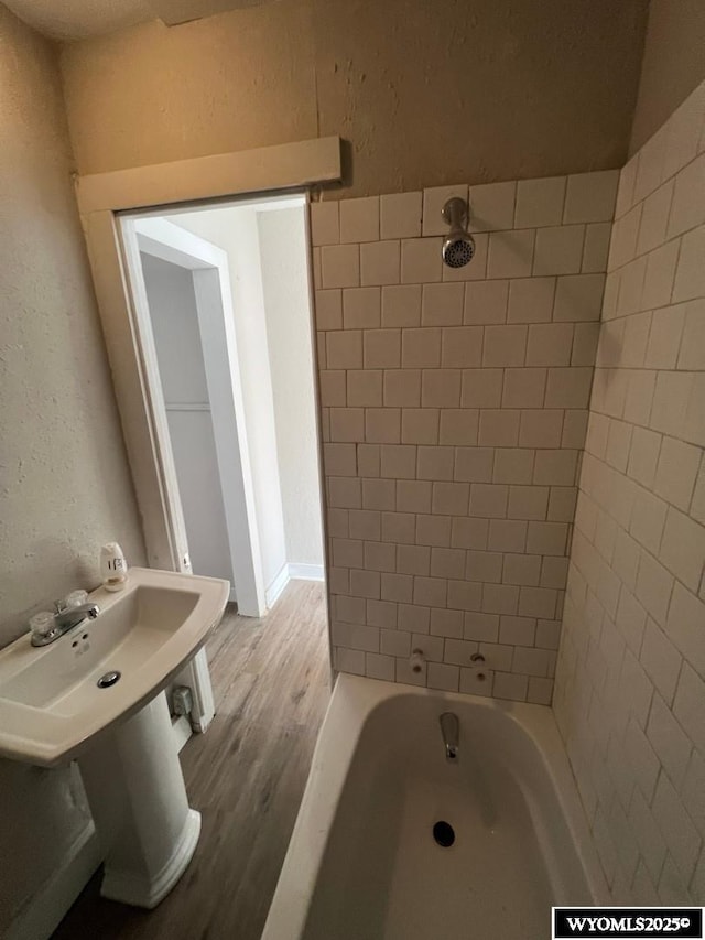 bathroom with tiled shower / bath and wood-type flooring