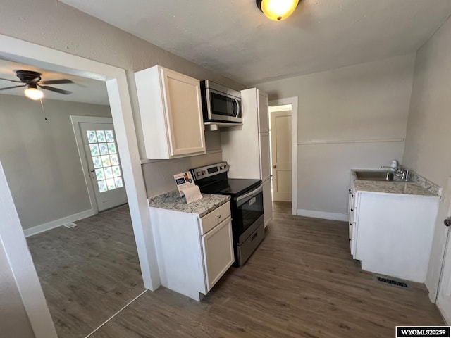 kitchen with sink, dark wood-type flooring, ceiling fan, stainless steel appliances, and white cabinets