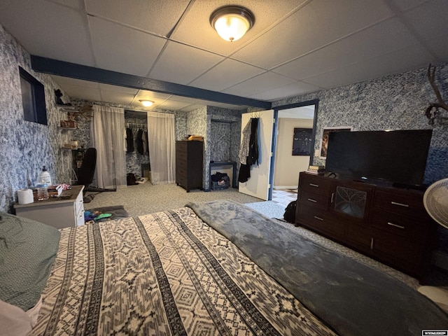 carpeted bedroom with a drop ceiling