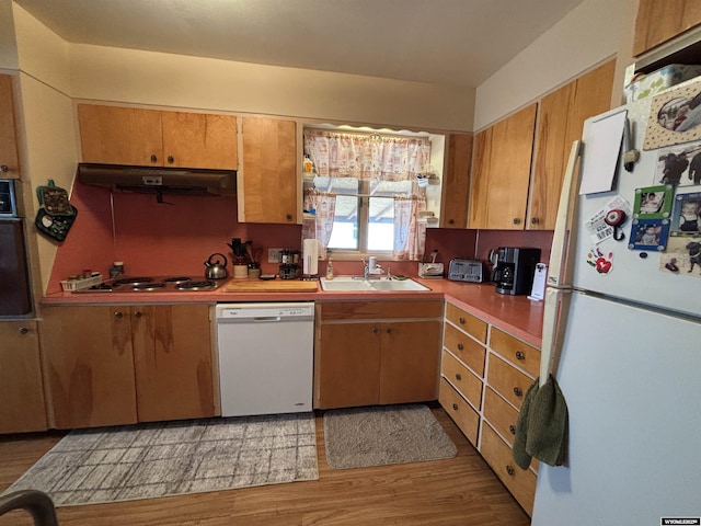 kitchen with white appliances, sink, and light wood-type flooring