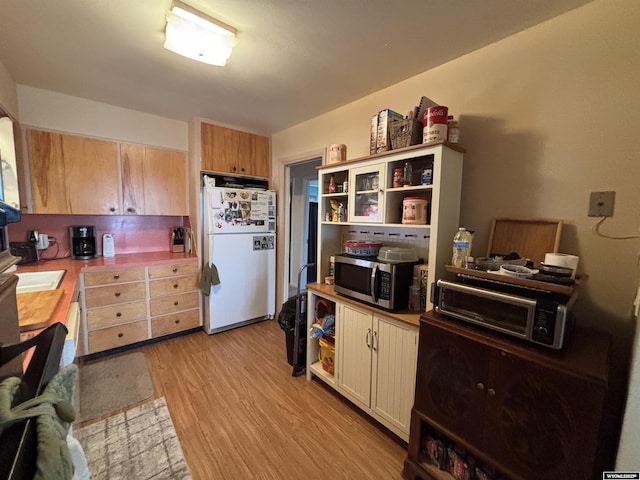 kitchen with light hardwood / wood-style floors and white refrigerator