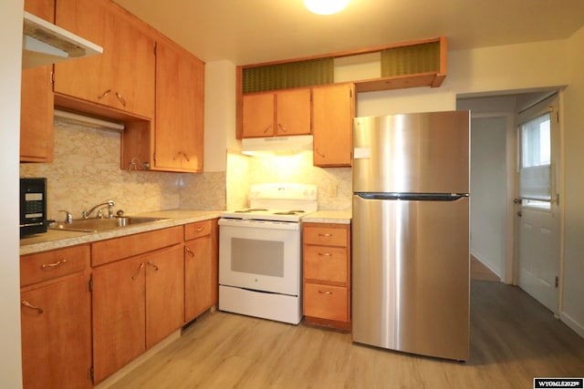 kitchen with white electric range, sink, backsplash, stainless steel fridge, and light wood-type flooring