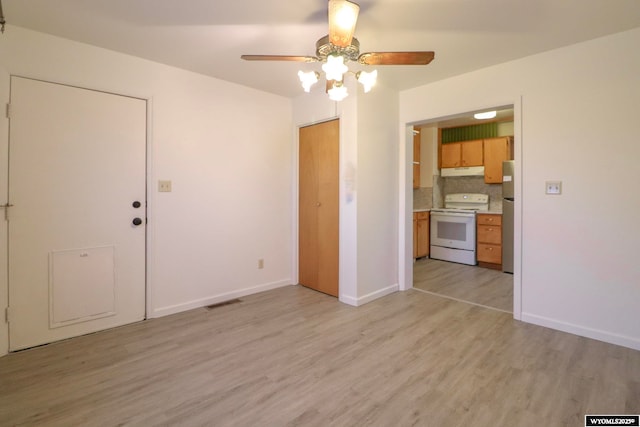 empty room with light hardwood / wood-style flooring and ceiling fan