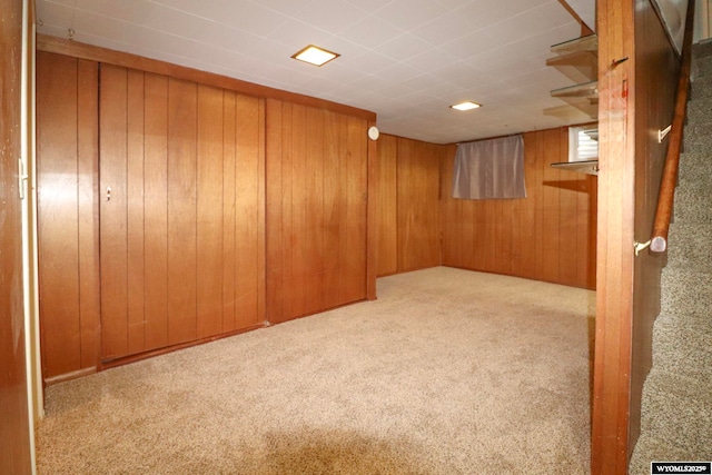 basement with light colored carpet and wood walls