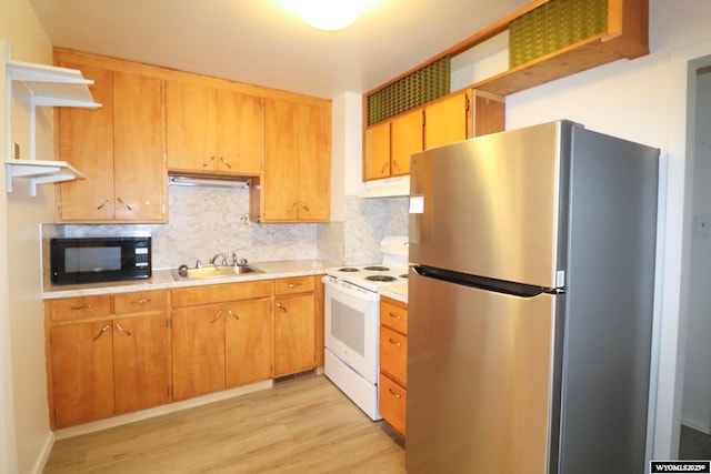 kitchen with sink, tasteful backsplash, stainless steel refrigerator, white range with electric cooktop, and light hardwood / wood-style floors