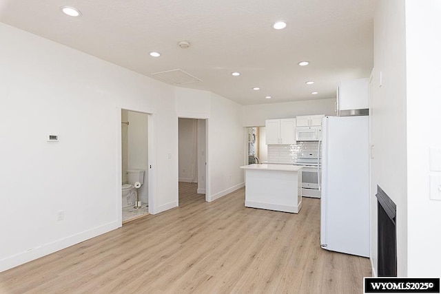 kitchen with white appliances, tasteful backsplash, light hardwood / wood-style floors, white cabinets, and a kitchen island